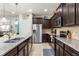 Well-designed kitchen with stainless steel appliances, dark wood cabinets, and granite countertops at 1909 Majorca Dr, Kissimmee, FL 34747