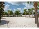 Sand volleyball court ready for a friendly game, surrounded by palm trees and landscaping at 1909 Majorca Dr, Kissimmee, FL 34747