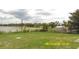 Expansive backyard with lake views, surrounded by lush greenery, and a storage shed at 1952 English Dr, Deltona, FL 32738
