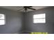 A bright bedroom featuring neutral walls, two windows offering views, and ceiling fan at 1952 English Dr, Deltona, FL 32738