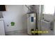 A utility room with a water heater, painted walls, and an air conditioning unit in the window at 1952 English Dr, Deltona, FL 32738