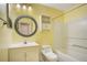 A bathroom with a tub-shower combo, round framed mirror, single sink vanity, and a standard toilet at 2053 Dixie Belle Dr # 2053J, Orlando, FL 32812