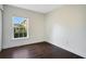 An empty bedroom featuring hardwood floors and a window that offers a view of the neighborhood at 2053 Dixie Belle Dr # 2053J, Orlando, FL 32812