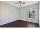A bright, empty bedroom with hardwood floors, a ceiling fan, and a window with a view at 2053 Dixie Belle Dr # 2053J, Orlando, FL 32812