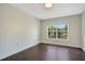 Bright bedroom with hardwood floors and a large window overlooking the lush exterior landscaping at 2053 Dixie Belle Dr # 2053J, Orlando, FL 32812