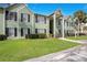 Inviting two-story condo building with vibrant green lawn, mature palms, and convenient resident parking at 2053 Dixie Belle Dr # 2053J, Orlando, FL 32812