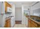 Open kitchen with granite countertops, wood cabinets, and white appliances overlooking the living spaces at 2053 Dixie Belle Dr # 2053J, Orlando, FL 32812