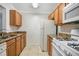 Functional kitchen with granite countertops, wooden cabinets, and white appliances at 2053 Dixie Belle Dr # 2053J, Orlando, FL 32812