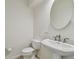 A close-up shot showcasing a pristine half bathroom with a pedestal sink and neutral decor at 207 S Sweetwater Blvd, Longwood, FL 32779