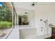 Bright bathroom features a soaking tub with mosaic tile and large window overlooking the backyard at 207 S Sweetwater Blvd, Longwood, FL 32779