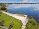 Aerial view of a lakeside beach with picnic tables, swim area and dock at 207 S Sweetwater Blvd, Longwood, FL 32779