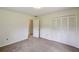 Bright bedroom featuring a closet with white bi-fold doors and neutral carpet at 207 S Sweetwater Blvd, Longwood, FL 32779