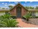 Welcoming brick facade with a decorative front door and lush landscaping at 207 S Sweetwater Blvd, Longwood, FL 32779