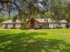 Charming single-story home boasts a lush front yard, mature trees, and a brick facade entry at 207 S Sweetwater Blvd, Longwood, FL 32779