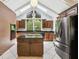 Bright kitchen featuring a large island, stainless steel refrigerator, and vaulted ceiling with skylights at 207 S Sweetwater Blvd, Longwood, FL 32779
