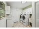 Clean laundry room featuring side-by-side washer and dryer and ample storage cabinets at 207 S Sweetwater Blvd, Longwood, FL 32779