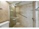 Updated shower featuring glass enclosure, tiled walls, shelving, grab bars and handheld shower fixture at 207 S Sweetwater Blvd, Longwood, FL 32779