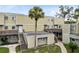A sunny exterior view showcases the apartment buildings, lush landscape, stairs and walkways around the property at 208 Scottsdale Sq # 208, Winter Park, FL 32792