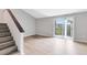 Bright living room with sliding glass doors and light wood flooring leading to stairs at 208 Scottsdale Sq # 208, Winter Park, FL 32792