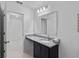 Well-lit bathroom featuring a granite countertop, dark cabinets, and a large mirror at 232 Summerlin Loop, Haines City, FL 33844