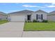 Charming single-story home featuring a two-car garage and a well-maintained lawn at 232 Summerlin Loop, Haines City, FL 33844