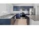 Modern kitchen boasts stainless steel appliances and granite countertops with sleek, blue cabinets at 232 Summerlin Loop, Haines City, FL 33844