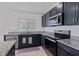 Well-lit kitchen includes stainless steel appliances, dark cabinetry, and granite countertops at 232 Summerlin Loop, Haines City, FL 33844