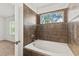 Bathroom with tile surround, soaking tub, and window at 232 Windflower Way, Oviedo, FL 32765