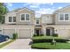 Townhouse exterior features a two-story design with attached garages and manicured landscaping at 232 Windflower Way, Oviedo, FL 32765