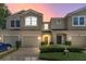Townhouse exterior features a two-story design with attached garages and manicured landscaping at 232 Windflower Way, Oviedo, FL 32765