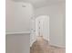 Upstairs hallway with neutral carpet, arched doorway and white trim at 232 Windflower Way, Oviedo, FL 32765