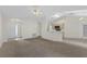 Spacious living room with carpet flooring, complemented by neutral walls, ceiling fan and skylights, open to the kitchen at 2404 Sw 20Th Ter, Ocala, FL 34471