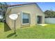 View of the backyard with a sliding glass door, window, and satellite dish at 2422 Condado Ct, Kissimmee, FL 34743