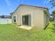 Fenced-in backyard featuring healthy green grass and a concrete patio with sliding glass doors at 2422 Condado Ct, Kissimmee, FL 34743