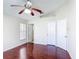 This bedroom features a ceiling fan, wood floors, neutral paint and three doors at 2422 Condado Ct, Kissimmee, FL 34743