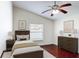 This bedroom features a ceiling fan, wood floors, a window with blinds and neutral paint at 2422 Condado Ct, Kissimmee, FL 34743
