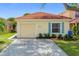 Charming single-story home featuring a red tile roof, light yellow siding, and a single-car garage at 2422 Condado Ct, Kissimmee, FL 34743