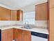 A bright kitchen features wooden cabinets, white countertops with a tile backsplash, and stainless steel appliances at 2422 Condado Ct, Kissimmee, FL 34743