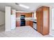 A bright kitchen features wooden cabinets, tile flooring, black appliances, and white countertops and backsplash at 2422 Condado Ct, Kissimmee, FL 34743