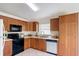 A bright kitchen features wooden cabinets, tile flooring, black appliances, and white countertops and backsplash at 2422 Condado Ct, Kissimmee, FL 34743