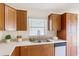 A bright kitchen features wooden cabinets, white countertops with a tile backsplash, and stainless steel appliances at 2422 Condado Ct, Kissimmee, FL 34743