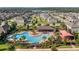 Aerial view showcases community pool and playground, surrounded by homes and verdant landscaping at 2432 Riviera Ln, Minneola, FL 34715
