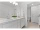 Clean, all white bathroom featuring double sinks, a large mirror, and a separate toilet room at 2432 Riviera Ln, Minneola, FL 34715