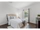 Cozy bedroom with a plush bed, soft blue accents, and natural light streaming through the window at 2432 Riviera Ln, Minneola, FL 34715