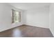 This bedroom has a large window dressed with patterned curtains and hardwood floors at 2432 Riviera Ln, Minneola, FL 34715