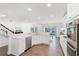 Modern kitchen featuring white cabinets, stainless steel appliances, and an open view of the living area at 2432 Riviera Ln, Minneola, FL 34715
