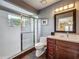 Bathroom featuring tiled shower, neutral finishes, and modern vanity with a well-lit mirror at 2558 Ballard Ave, Orlando, FL 32833