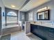 Elegant bathroom featuring a soaking tub, modern vanity, and decorative tile accents for a luxurious experience at 2558 Ballard Ave, Orlando, FL 32833