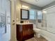 Cozy bathroom with a single vanity, shower-tub combo with sliding glass doors, and neutral finishes at 2558 Ballard Ave, Orlando, FL 32833