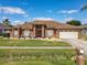 Charming home features a manicured lawn, decorative shrubbery, and an attached two-car garage at 2558 Ballard Ave, Orlando, FL 32833